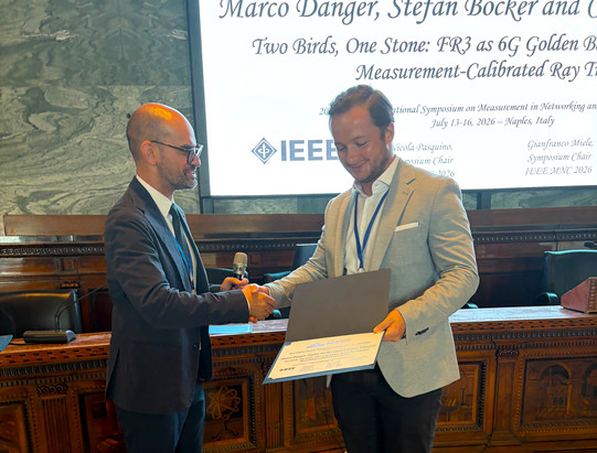 ComNets researcher Marco Danger receives Best Paper Award from Technical Program Chair Federico Tramarin.
