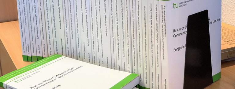 Several PhD books on a shelf